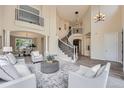 Bright living room boasts soaring ceilings, a curved staircase, and stylish decor and furnishings at 22019 E Arbor Dr, Aurora, CO 80016