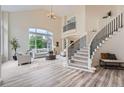 Bright living room with soaring ceilings, a staircase, large windows, and neutral decor at 22019 E Arbor Dr, Aurora, CO 80016
