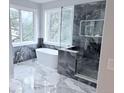 Spa-like bathroom with soaking tub, glass shower and marble-tiled floor at 22019 E Arbor Dr, Aurora, CO 80016