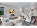 Cozy living room featuring contemporary furniture, a staircase, and a modern entertainment center at 9972 Wheeling St, Commerce City, CO 80022