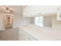 The kitchen offers white cabinets, a breakfast bar overlooking the living room, and ample counter space for meal preparation at 9005 E Lehigh Ave # 16, Denver, CO 80237