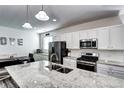 Modern kitchen with stainless steel appliances, granite countertops and bright white cabinetry at 802 Eva Peak Dr, Erie, CO 80516