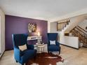 Cozy living room featuring hardwood floors, wainscoting, and an open staircase at 21258 E Aberdeen Pl, Centennial, CO 80015