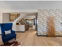 Open-concept living room featuring a staircase, hardwood floors, and stylish decor at 21258 E Aberdeen Pl, Centennial, CO 80015