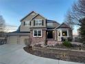 Inviting two-story home with brick accents, a three-car garage, and professionally landscaped front yard at 2522 W Dry Creek Ct, Littleton, CO 80120