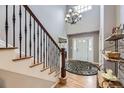 Bright and airy foyer featuring hardwood floors, a staircase, and a stylish chandelier at 2522 W Dry Creek Ct, Littleton, CO 80120