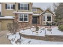 Inviting front entrance with brick accents, a charming bay window, and a well-kept front yard at 2522 W Dry Creek Ct, Littleton, CO 80120