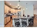 Open concept kitchen with wood floors, granite counters, stainless appliances, and counter seating at 13385 Jasmine St, Thornton, CO 80602