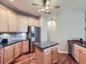 Bright kitchen featuring an island, stainless steel appliances, and hardwood flooring at 13385 Jasmine St, Thornton, CO 80602