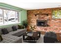 Spacious living room featuring a brick fireplace and large window with natural light at 5063 W 61St Ave, Arvada, CO 80003