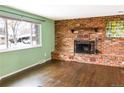 Bright living room with beautiful hardwood floors and a classic brick fireplace at 5063 W 61St Ave, Arvada, CO 80003