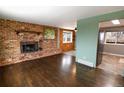 Spacious living room with brick fireplace, hardwood floors, and bright natural light at 5063 W 61St Ave, Arvada, CO 80003