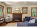 Inviting living room boasts a brick fireplace, wood trim windows, and comfortable seating at 652 N Gilpin St, Denver, CO 80218