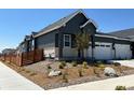 Landscaped front yard of a one-story grey home with white trim, including rock features and a privacy fence at 3401 N Denali St, Aurora, CO 80019