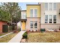 Modern townhouse showcasing a brick facade, a small balcony, and a well-maintained front yard at 3221 Perry St, Denver, CO 80212