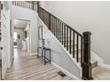 Elegant staircase with wooden banister and neutral carpet, complemented by stylish decor and wood floors at 16075 E 109Th Pl, Commerce City, CO 80022