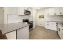 Bright kitchen is equipped with stainless steel appliances, quartz countertops and modern tile flooring at 7691 Osage St, Denver, CO 80221