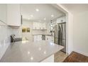 Modern kitchen with stainless steel appliances, quartz counters, white cabinets, and a subway tile backsplash at 7691 Osage St, Denver, CO 80221