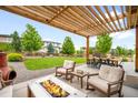 Back patio with a pergola, fire pit, and outdoor seating area at 9567 Juniper Way, Arvada, CO 80007