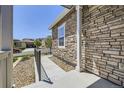 Exterior view of a home's stone facade, showcasing the front entrance and landscaping at 12685 W Montane Dr, Broomfield, CO 80021