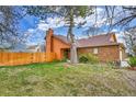 Charming brick home with well-kept lawn and wooden fence, creating a cozy curb appeal at 13028 Garfield Dr, Thornton, CO 80241