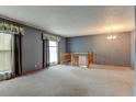 Comfortable living room features neutral carpet, wallpaper, and views of the outdoors at 9766 Fillmore St, Thornton, CO 80229
