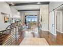 Bright living room with hardwood floors, fireplace, stone accent wall, and exposed ceiling beams at 4585 Mesa Top Dr, Monument, CO 80132