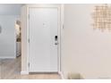 Inviting entryway featuring a secure door, neutral walls with elegant art, and a glimpse of the laundry area at 12172 Melody Dr # 102, Denver, CO 80234