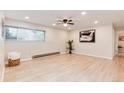 Bright living room showcasing a ceiling fan, large window, modern décor, and light wood-look floors at 12172 Melody Dr # 102, Denver, CO 80234