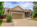 Inviting home with neutral siding, a two-car garage, and a well-maintained front yard at 9215 W Swarthmore Dr, Littleton, CO 80123