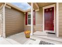 A welcoming front porch features a red door, matching shutters, and decorative flower pot at 9215 W Swarthmore Dr, Littleton, CO 80123