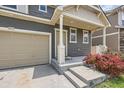 This home features a two-car garage, neutral siding, and a concrete entryway with manicured flowerbeds at 4414 Walden St, Denver, CO 80249