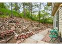 Tranquil backyard featuring a rock garden, mature trees, and outdoor seating area at 404 Raspberry Ln, Monument, CO 80132