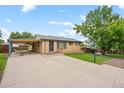 Charming brick home featuring a carport and long driveway at 6627 Eaton St, Arvada, CO 80003