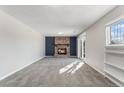 Inviting living room features a brick fireplace, neutral paint, plush carpeting, and a sliding door to the exterior at 1793 S Nucla St, Aurora, CO 80017