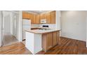 Well-lit kitchen with a center island, ample cabinet space, and wood flooring at 6803 W Yale Ave, Lakewood, CO 80227