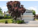 Charming two-story home with a well-manicured lawn, mature trees, and a two-car garage at 7371 Otis Ct, Arvada, CO 80003