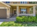 Inviting front porch showcasing stone accents, a charming wood door, and manicured shrubbery at 1905 Graphite Ct, Castle Rock, CO 80108