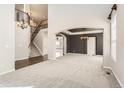 Open-concept living area with hardwood floors, elegant staircase, and stylish lighting fixtures at 1905 Graphite Ct, Castle Rock, CO 80108