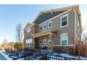 Charming two-story home with stone accents, a covered porch, and a well-maintained front yard in winter at 1126 S Yampa St, Aurora, CO 80017