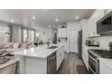 Gourmet kitchen with stainless steel appliances, white cabinets, and open floor plan at 1126 S Yampa St, Aurora, CO 80017