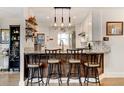 Kitchen features modern pendant lighting, granite countertops, breakfast bar, and stainless steel appliances at 4509 Eliot St, Denver, CO 80211