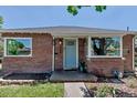 Charming brick home featuring a light blue front door and updated fixtures at 3550 Magnolia St, Denver, CO 80207