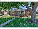 Charming brick home with a well-manicured lawn and inviting curb appeal at 3550 Magnolia St, Denver, CO 80207
