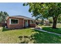Charming brick home with a lush front yard and inviting curb appeal at 3550 Magnolia St, Denver, CO 80207