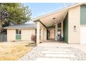 Inviting covered front porch with modern pendant lighting and wood front door at 102 Jackson Cir, Louisville, CO 80027