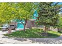Inviting exterior showcasing lush greenery, a well-maintained lawn, and a charming, covered front porch at 12333 Newport Ct, Brighton, CO 80602
