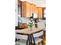 Dining area features a modern table set, with a view to the kitchen and its wooden cabinets at 3737 Jason St, Denver, CO 80211