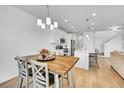 Dining area with a modern chandelier, wood table, and access to the kitchen and living area at 4027 E 98Th Pl, Thornton, CO 80229
