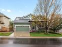 Charming home featuring a two-car garage, manicured lawn, and a cozy front porch at 5377 Cloverbrook Cir, Highlands Ranch, CO 80130
